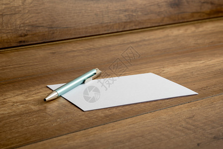 圆球笔和空白卡或纸条都放在木制桌子上图片