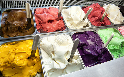 在冰淇淋店或商店的橱窗里展示各种新鲜制作的不同果味意大利冰淇淋图片