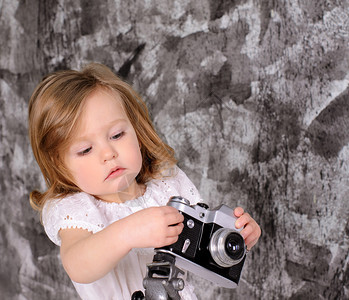 可爱的小女孩在灰墙背景上调图片
