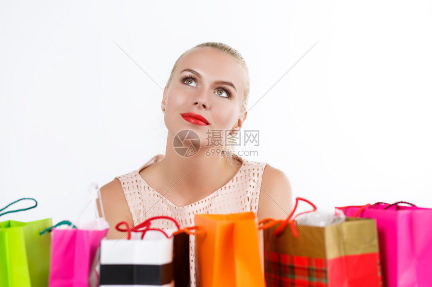 美丽周到的金发女人梦想着用彩色纸袋买新鲜的东西和礼物购物消费主义和交付概念生日快图片