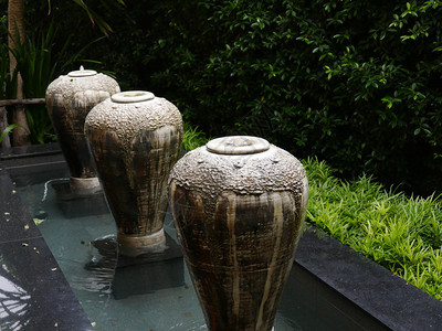 陶瓷投手喷泉装饰在房子的花园里图片