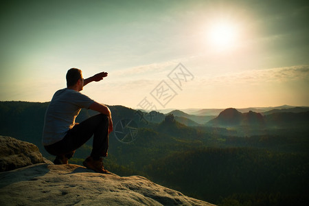 人类坐在岩石的顶峰上图片