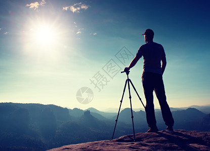 专业摄影师在悬崖和思维上守着三脚架图片