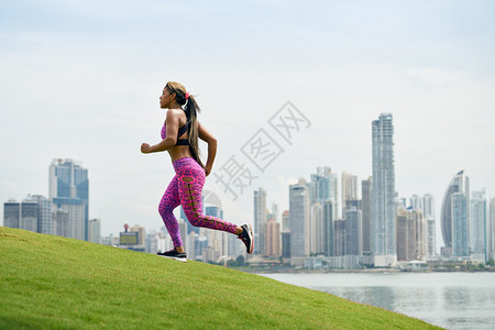 她骑在一座小山上直冲天际线跑来去的在城市清晨奔跑和锻炼的年图片