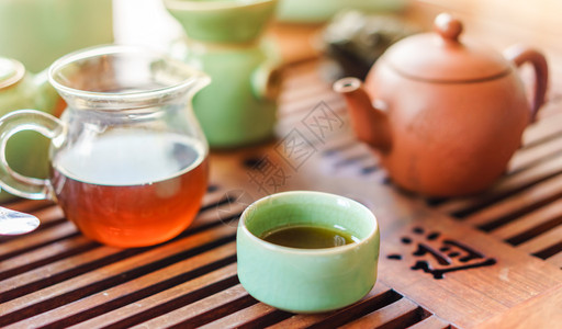 绿色茶壶和茶杯加茶袋上面图片