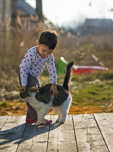 小女孩和猫在外面玩耍图片