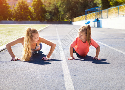 母亲和小女儿正在体育场做运动一家人在体育场做健身健图片