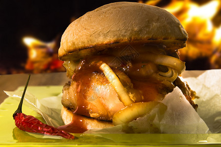 香辣烤猪肉包配辣椒酱和青盘洋葱背景是火图片