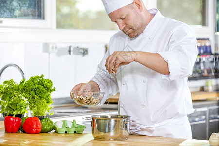 专业厨师切开蔬菜在工业厨房做饭图片