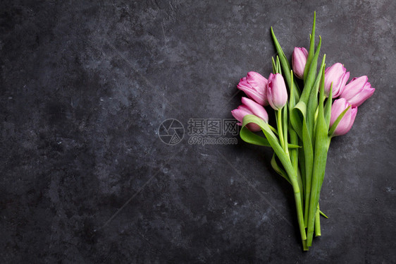 黑石桌上的鲜紫色郁金花带有复制空图片