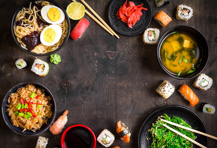 黑暗背景下的寿司和日本料理寿司卷日式裙带菜味噌汤拉面蔬菜炒饭握寿司鲑鱼排酱油筷子亚洲图片