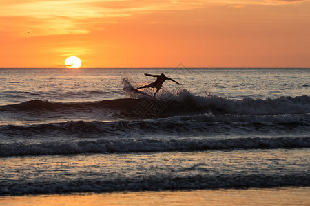 Surfersillhouette享受在哥斯达黎加PlayaNe图片