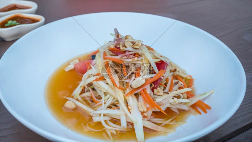 白盘上的泰式辣木瓜沙拉亚洲菜图片