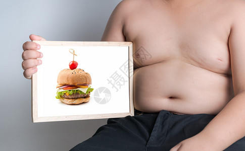 胖男孩在白板上展示汉堡照片图片