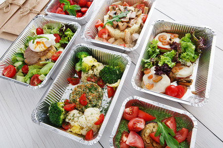 健康食品餐厅交付和饮食概念带走健身餐铝箔盒中的午餐蔬菜馅饼背景图片