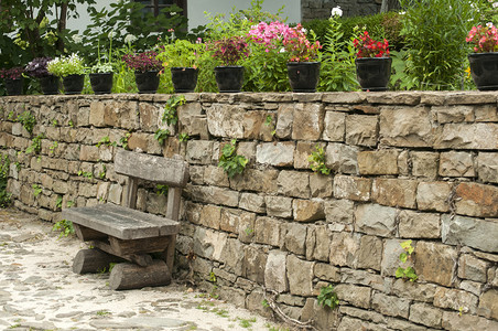 石墙前的长木凳和花盆图片