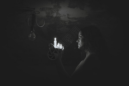 她将蜡烛照在灯泡上背景图片