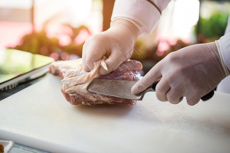 刀切生肉用橡皮手套做饭厨师准备图片