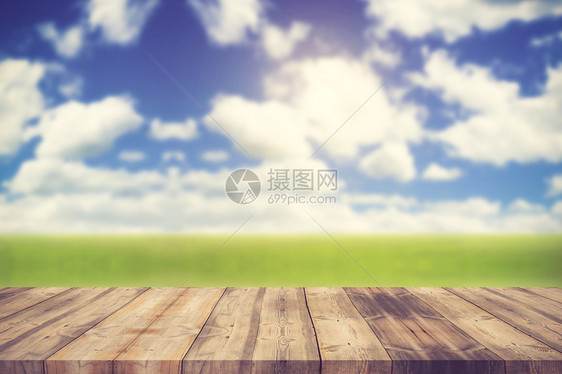 模糊蓝天和绿草原背景上的木质顶台可以用于补假或显示您的产品Vint图片