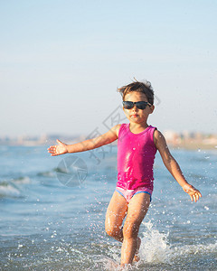 海边浪中奔跑的可爱孩子图片