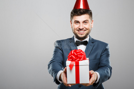 穿着西装的男人带着弓和生日红帽子图片
