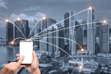 手持智能手机和新加坡城市与网络连接智慧城市图片