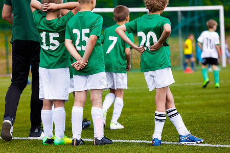 指导青少年运动足球教练在球场上的年轻男孩青年足球队与教练和儿童运图片