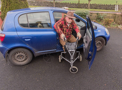 老年男老人步行到带残疾的汽车移动轻型滚轮折叠三步行者步行框架齐默图片