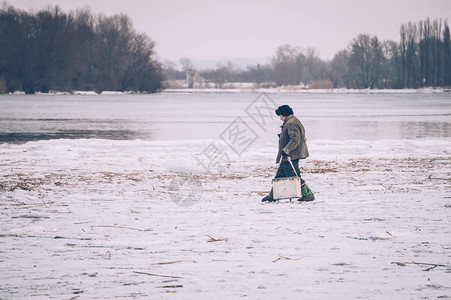 冬季捕鱼渔民在河边图片
