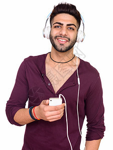 电影演播室拍摄年轻快乐的印度男子在白人背景下使用手机时听音乐图片