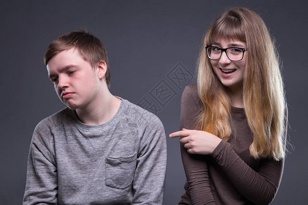 灰色背景中冷笑的年轻女人和男人图片