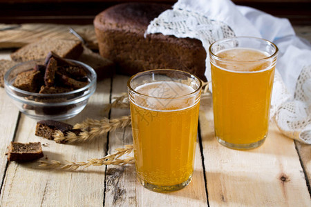 传统的俄罗斯冷黑麦在玻璃杯和木桌上的水罐中喝克瓦斯来自面包黑麦芽糖背景图片