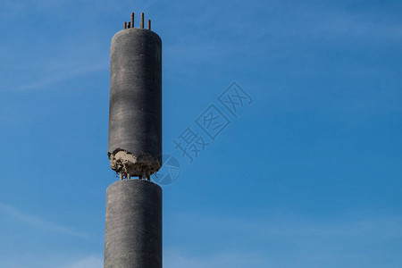 在蓝色天空背景的圆形混凝土柱体顶部建造图片