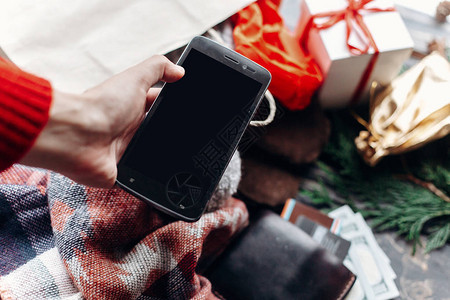 手持电话用空屏幕在生锈背景钱包和圣诞图片