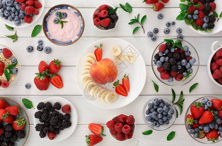 希腊酸奶新鲜草莓覆盆子蓝莓和黑莓将水果拼盘放在白色木头上图片