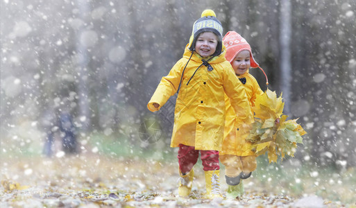 蹒跚学步的孩子们在秋天的公园里散步秋林初霜雪孩子们在公园背景图片