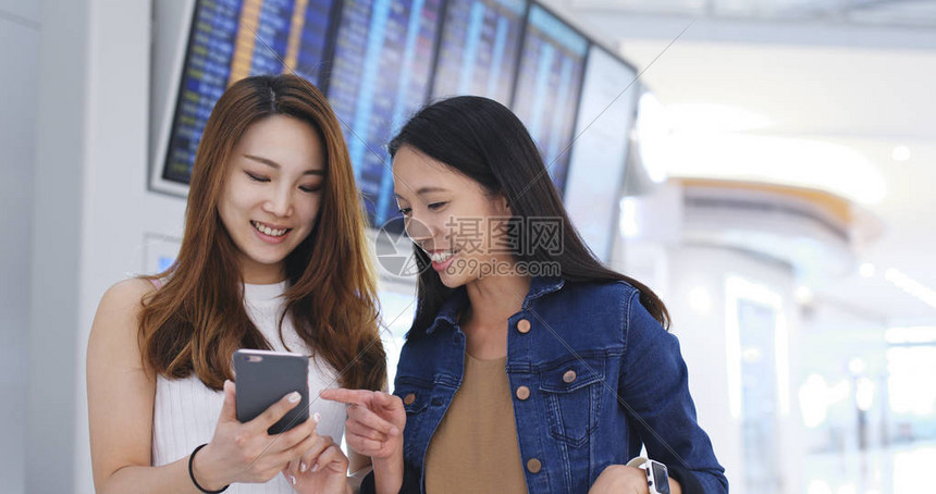 女孩朋友在香港机场用手机检查时间图片