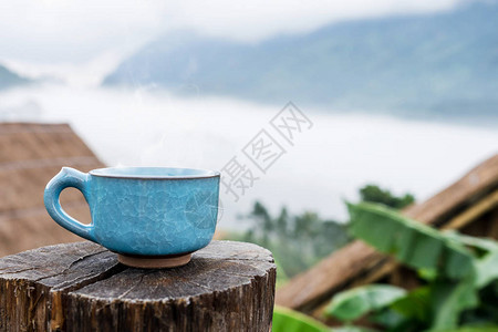 火热咖啡杯在木头和家居露营在道图片