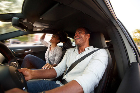 男人和女人在汽车里微笑和坐图片