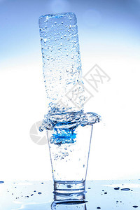 空瓶子装在一杯水里溅起水花和倒影图片