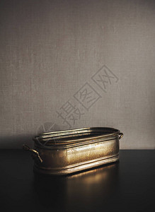 深色墙壁背景上的老式铜质金属碗图片