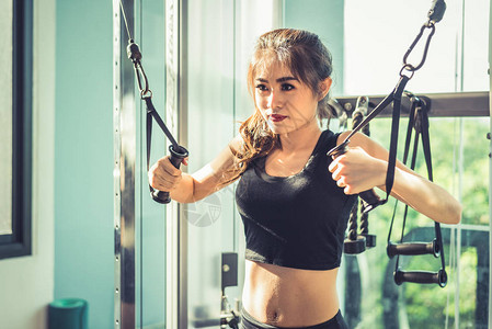 亚洲年轻女子在交叉健身馆做弹力绳练习力量训练和肌肉与健康概念器材和俱图片