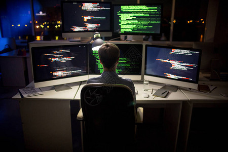 坐在电脑和书写代码前的辛勤工作的编程序员的近视背景图片