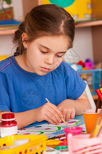 小学生在艺术学校课上画孩子在桌子上用颜料画幼儿园里的女孩绘画教育培养孩子的创造能力春图片