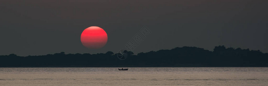 海上夕阳红日与渔船背景图片