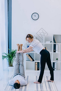 商人和他的教练瑜伽在办公室的背景图片