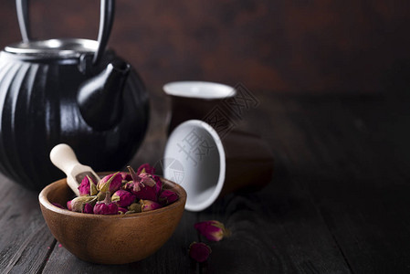 木碗上的玫瑰芽茶和深木背景的茶图片