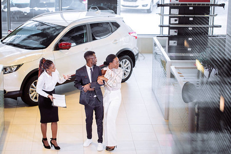 非洲汽车销售员站在经销商面前向非洲夫妇顾客讲述汽车特征的高角度视野Name图片
