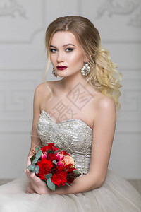 穿着婚纱的年轻漂亮的新娘带新娘花束在室图片
