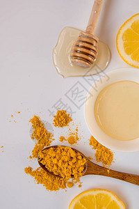 蜂蜜棒汤匙加姜黄和柠檬片背景图片
